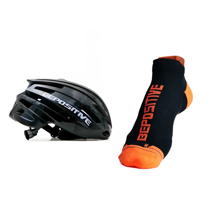 A black bepositive cycling helmet and orange bepositive Ankle socks on a white background