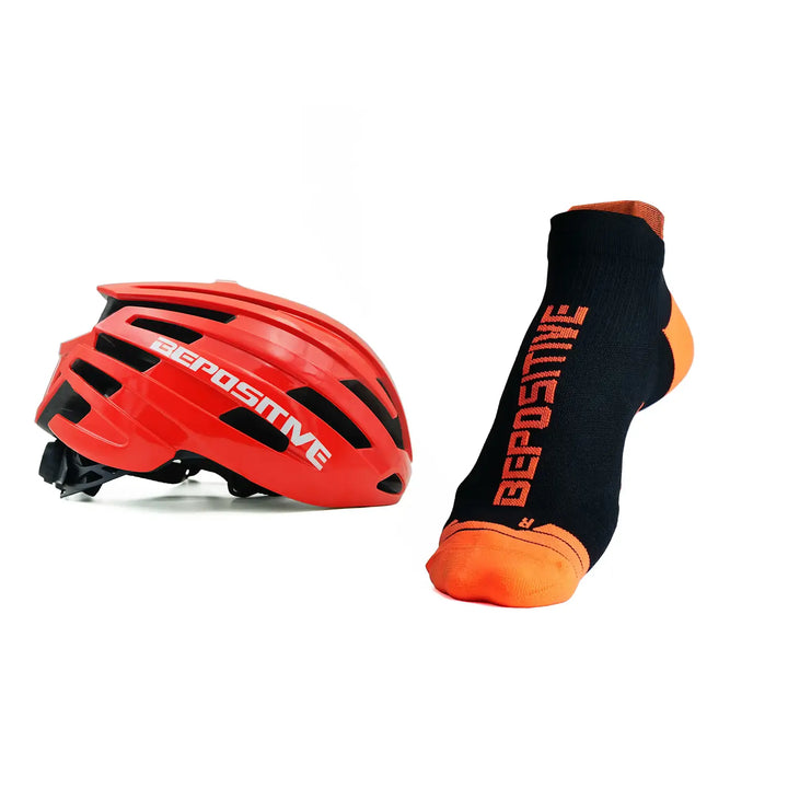 A orange bepositive cycling helmet and orange bepositive Ankle socks on a white background