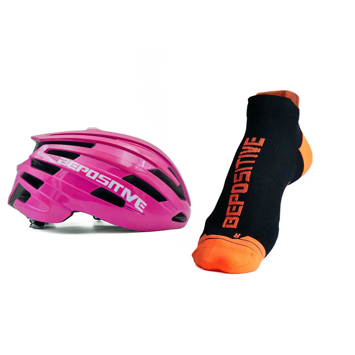 A pink bepositive cycling helmet and  orange bepositive Ankle socks on a white background