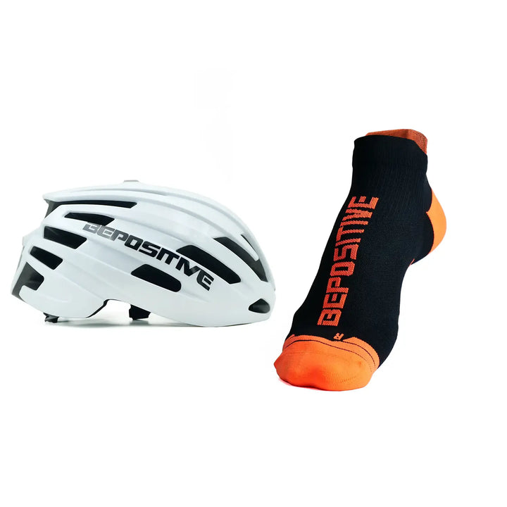 A white bepositive cycling helmet and orange bepositive Ankle socks on a white background