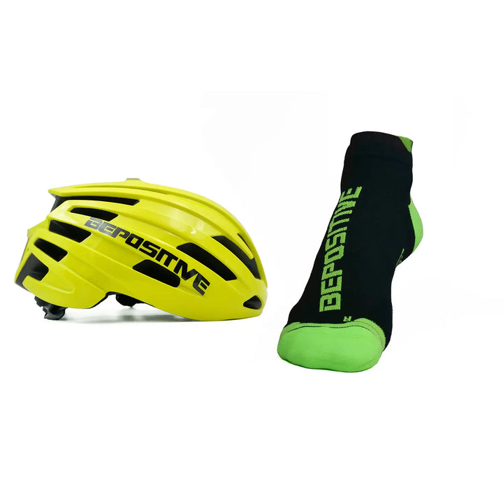 A yellow bepositive cycling helmet and green bepositive Ankle socks on a white background