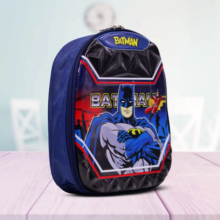 Angle view of a Batman backpack on a light pink surface with a light blue background