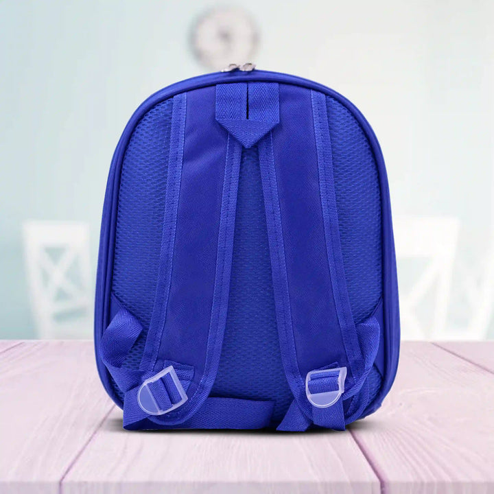 Blue backpack on a light pink surface with a blurred background